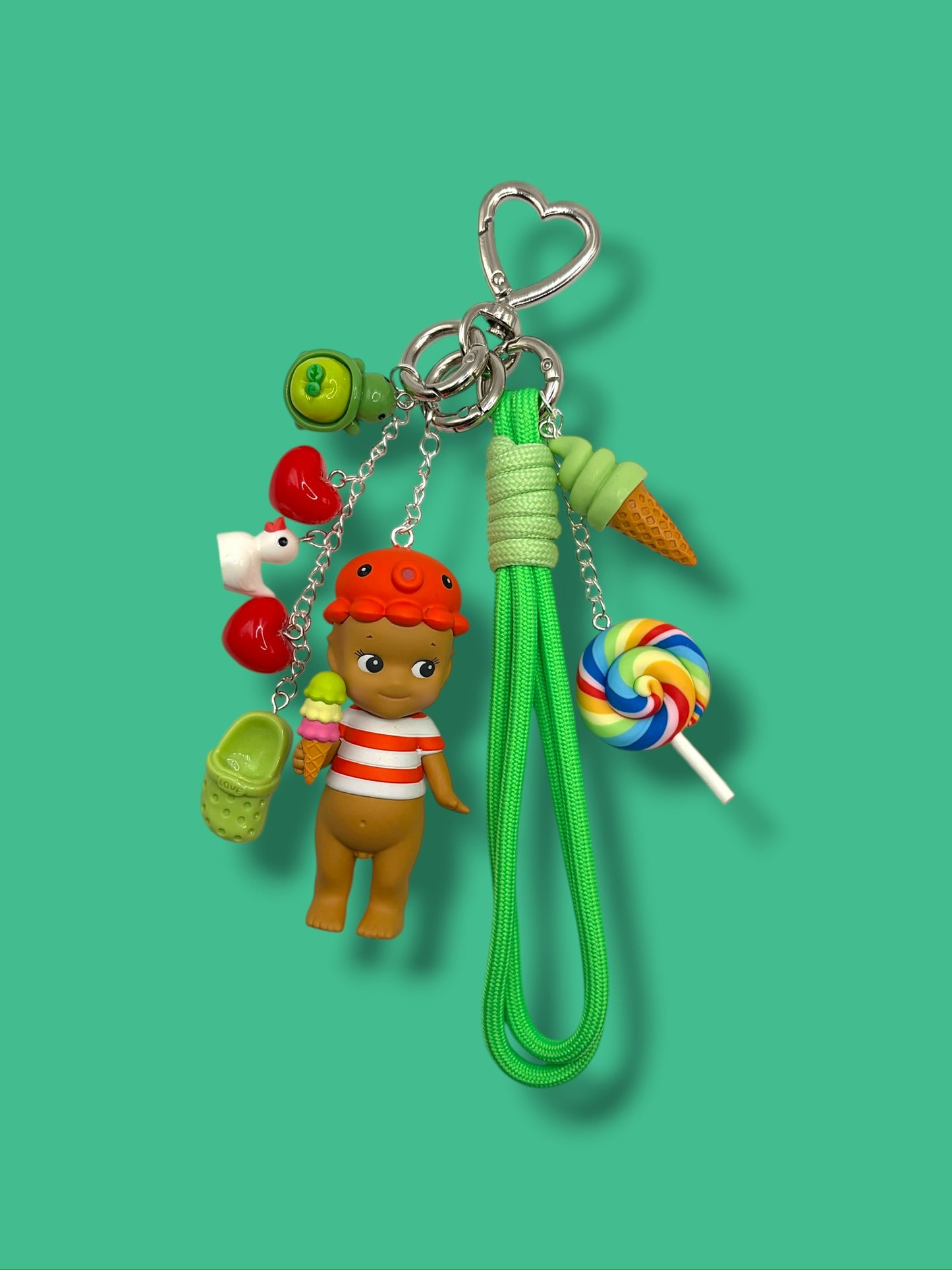 Sonny Angel charm keychain with rainbow lollipop, ice cream cone, heart charms, mini clog, and green braided wrist strap