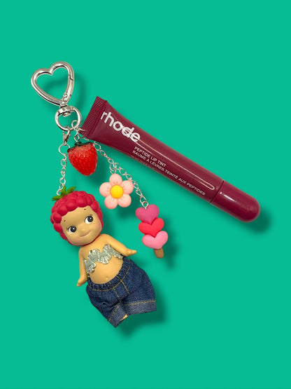 Strawberry Sonny Angel bag charm with heart clasp, strawberry, daisy, and heart ice cream charms on teal background